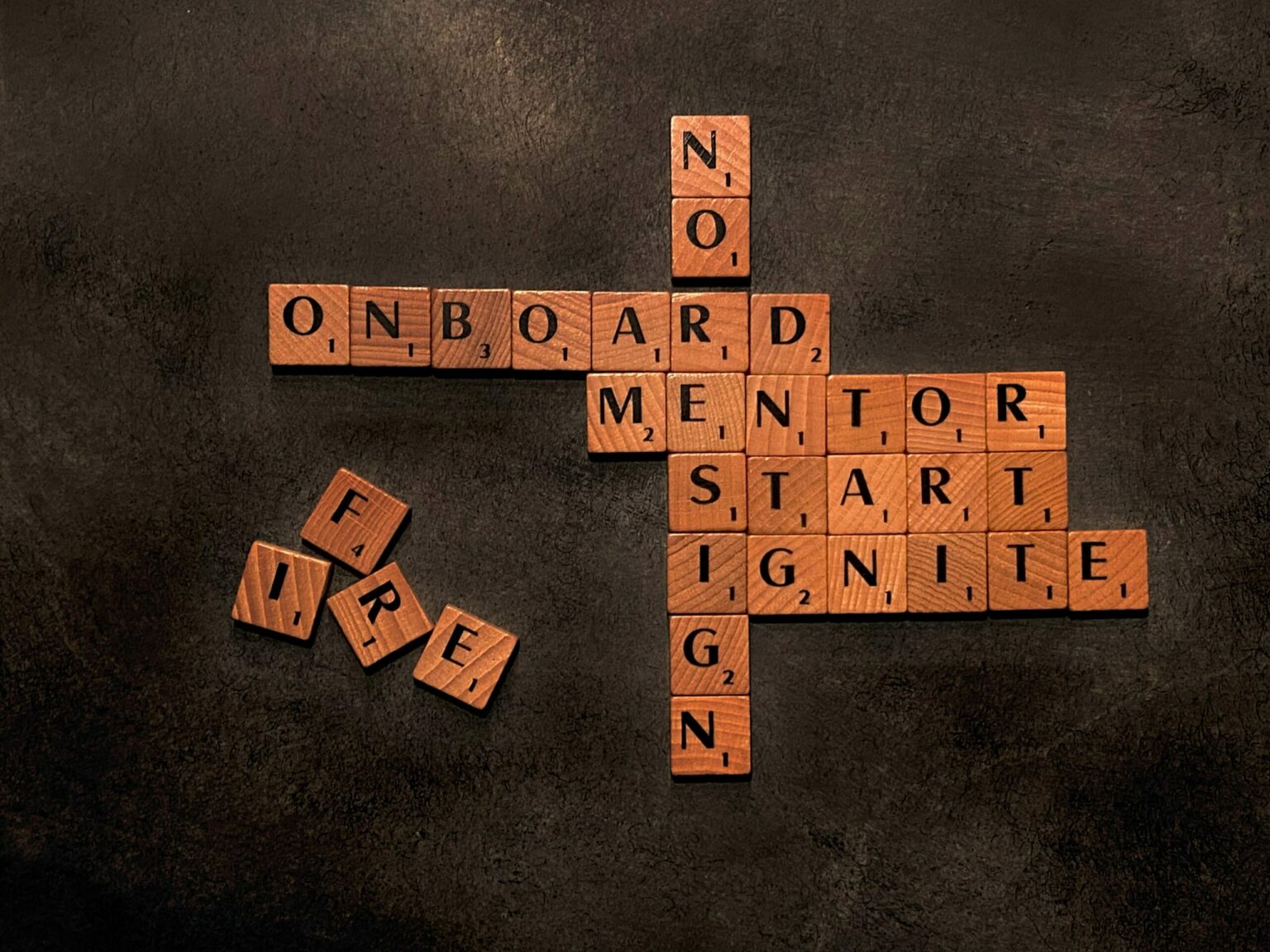 scrabble letters spelling onboard, mentor, start, ignite