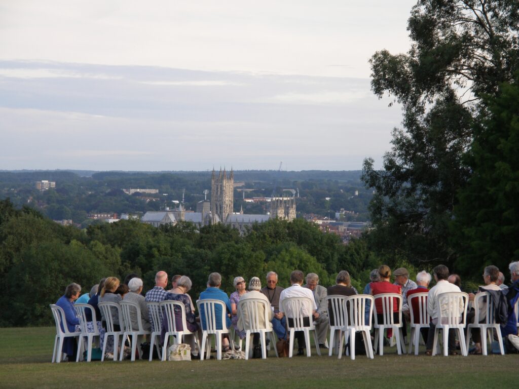Quakers in a circle worshipping with Canterbuy Cathedral behind