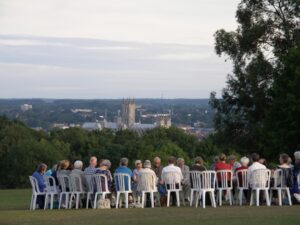 Quakers in a circle worshipping with Canterbuy Cathedral behind