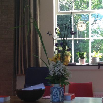 a vase of flowers on a table with folders